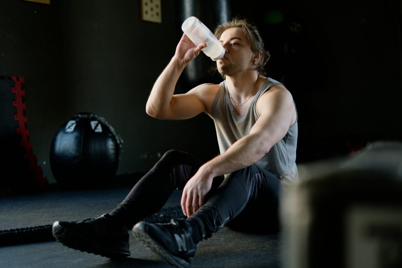 why do muscles hurt after working out – man resting after workout and drinking water to recover muscles