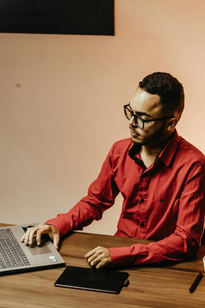 Man sitting at an office desk using a laptop
