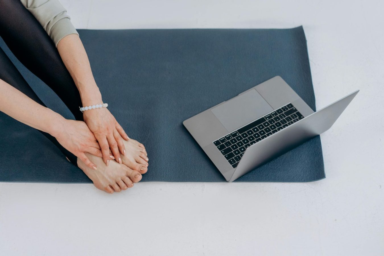 best home workouts for weight loss woman doing yoga with laptop at home