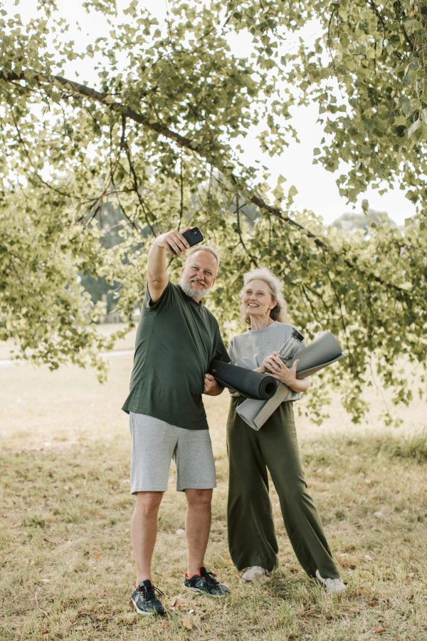 Older couple with yoga mats in park, gentle workouts and walking for how to quickly lower blood pressure