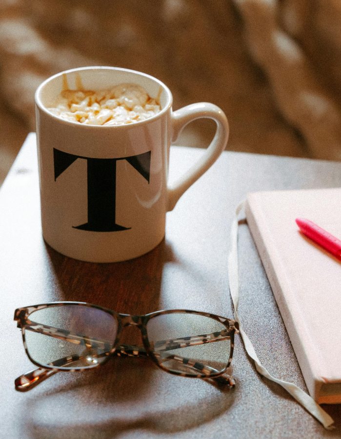 Notebook, coffee and glasses on desk
