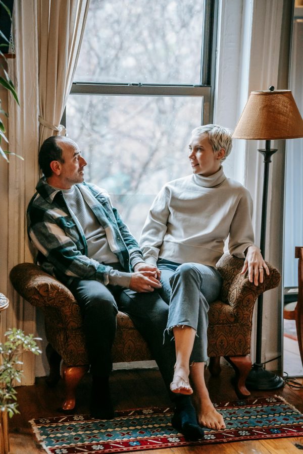 How Relationships Change After 40 — mature couple resting on a couch and talking by the window