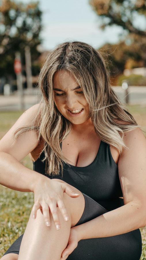 morning knee pain woman holding knee outdoors