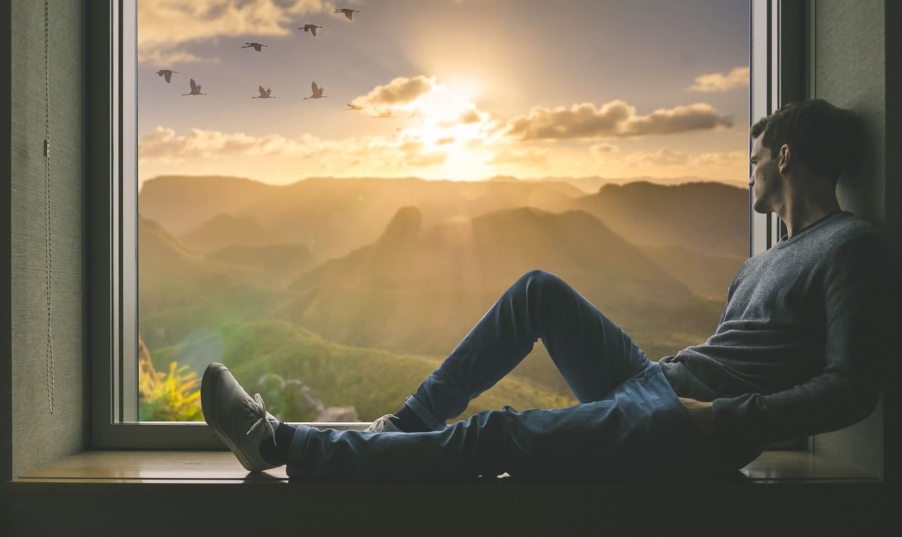 Man sitting by a window, looking outside